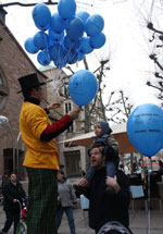 Stelzenmann verteilt ballons